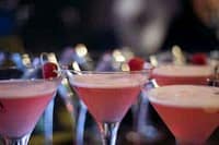 Elegant pink cocktails with raspberries at a fine dining event.