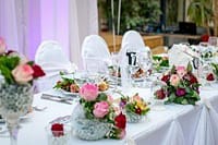 Elegant wedding table setting with floral arrangements and fine dining essentials.