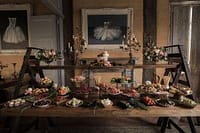 Elegant private chef dinner setup with gourmet dishes and floral décor in a rustic dining room.
