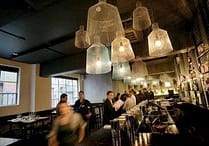 Elegant restaurant interior with chef and guests enjoying fine dining experience.