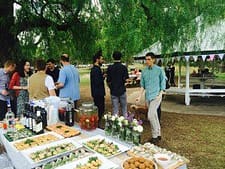 Elegant outdoor private chef event with gourmet food and wine in a lush garden setting.