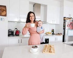 Elegant woman with child enjoying a home-cooked meal in modern kitchen, private chef service Australia.