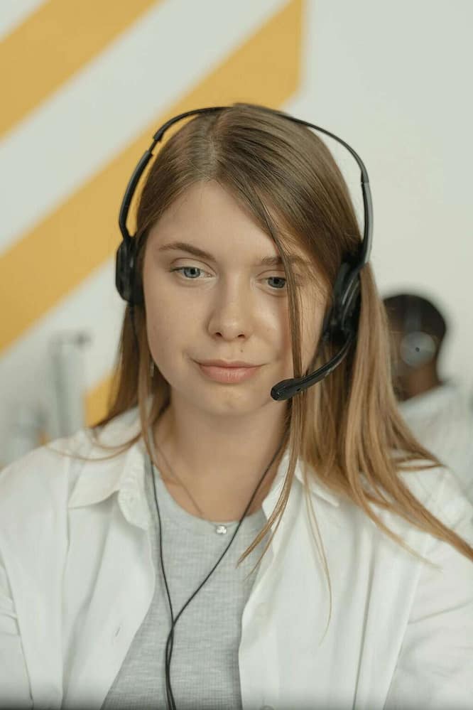 Professional woman wearing headphones, providing excellent customer service in a modern office setting.